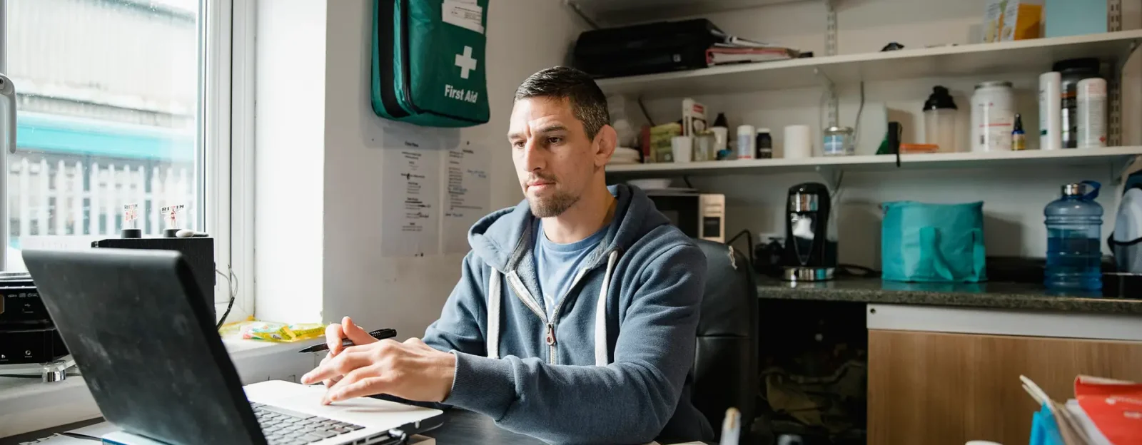 Mid-adult man is working on a laptop in his office.